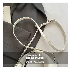 Detail of white crocodile texture leather adjustable strap with silver metal buckle