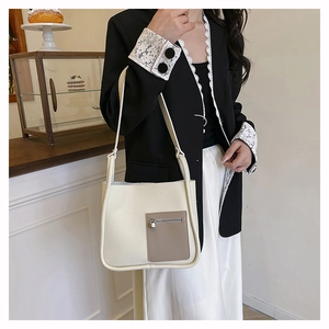 Chic cream litchi texture shoulder bag with contrast grey pocket shown in lifestyle setting
