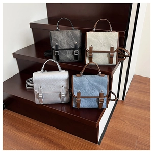 Retro style square backpacks in charcoal, beige, silver, and denim blue on wooden stairs