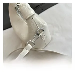 Close-up of premium silver metal hook on white crocodile pattern crossbody bag detail