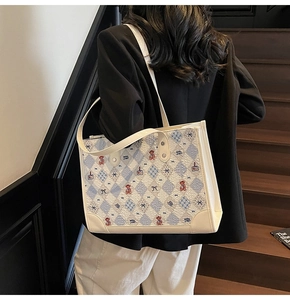 Vue détaillée du grand sac cabas beige avec imprimé ours porté par un mannequin