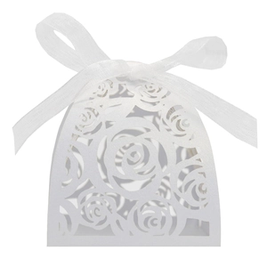Close-up of laser-cut white rose gift box with elegant ribbon for wedding favors