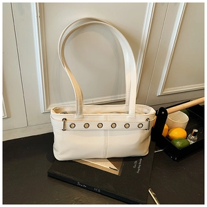 Dettaglio della borsa tote bianco crema con occhielli argentati e pelle sintetica liscia