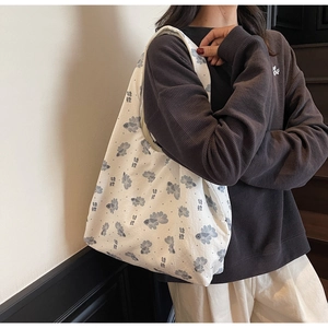 Detailed close-up of a floral canvas tote bag with blue koi fish pattern on white fabric