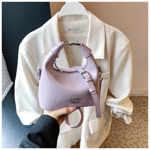 Detail of lavender crocodile texture faux leather handbag with silver logo and metal zipper