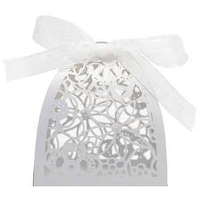 Detailed view of laser-cut floral pattern and white ribbon on the elegant wedding favor box