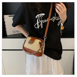 Close-up of woven crossbody shell bag featuring brown leather trim and silver chain