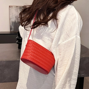 Detail of red woven leather shoulder bag showing the intricate texture and smooth base
