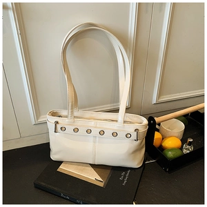 Dettaglio della borsa sottobraccio in pelle bianco crema con cinturino decorativo in metallo