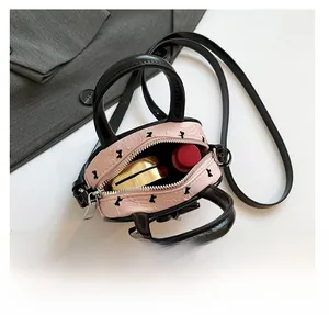 Interno della mini borsa rosa che mostra lo spazio per rossetto e trucchi vari