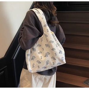 Detail of canvas tote bag featuring gray koi fish print and artistic floral pattern