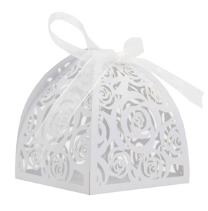 Detail of laser-cut rose patterns on white wedding candy box with a silk ribbon bow
