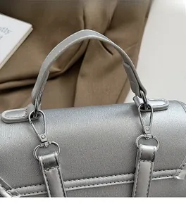 Detail of silver textured leather handbag showing high-quality metallic hardware and handle