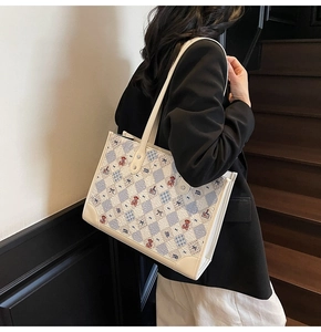 Détail du sac cabas à carreaux avec imprimés ours et finitions en cuir bleu texture