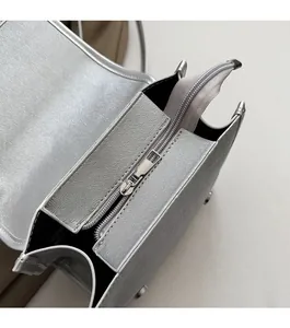 Detailed close-up of smooth silver top zipper and durable Saffiano texture on handbag