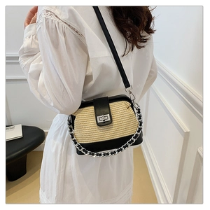 Close-up of contrast woven straw bag with silver twist lock and dual chain straps