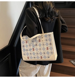 Détail de broderies d'ours et nœuds sur le sac cabas en tweed texturé