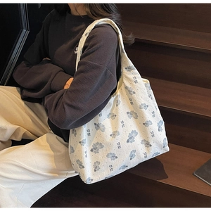Detail of white canvas tote bag with blue koi fish pattern and textured fabric surface