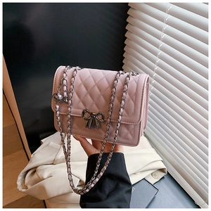 Détail du sac bandoulière rose matelassé avec fermoir nœud argenté et bandoulière chaîne