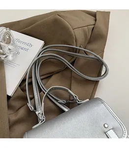 Detailed close-up of the silver glitter handbag with adjustable shoulder strap and handle