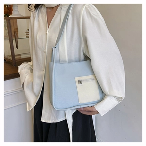 Lifestyle shot of light blue litchi pattern shoulder bag worn by a model