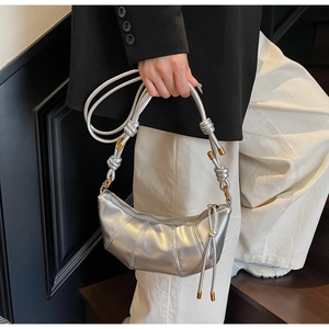 Detailed view of silver metallic pleated crescent bag with thick rope knot shoulder strap