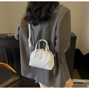 Chic white heart-shaped shoulder bag shown on model with sleek glossy PU leather finish