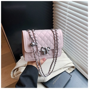 Détail du sac à bandoulière rose matelassé avec fermoir nœud argenté et chaîne