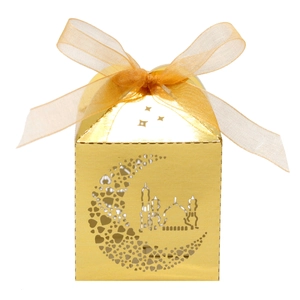 Macro detail of laser-cut moon and mosque pattern on golden hollow gift box with ribbon
