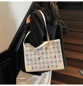 Détail du sac cabas blanc avec motif losange bleu et broderie ours pour femmes