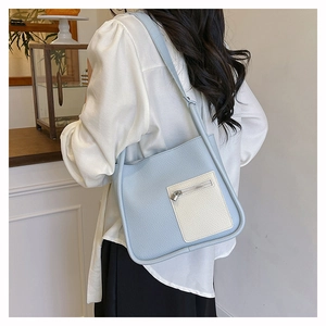 Detail shot of light blue lychee pattern shoulder bag with white pocket and metal zipper