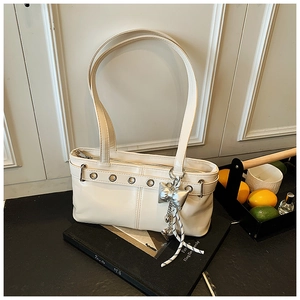 Dettaglio borsa sottobraccio in finta pelle bianco crema con fiocco argento e occhielli