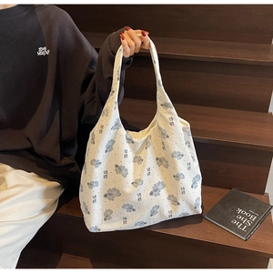 Detail of canvas tote bag featuring blue koi fish print and lucky koi character