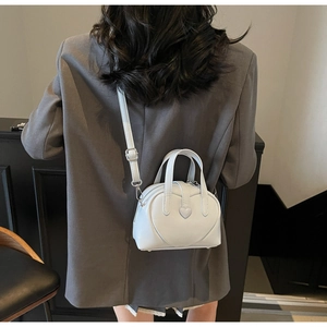 Detailed view of heart-shaped mini crossbody bag showing smooth PU leather and silver hardware