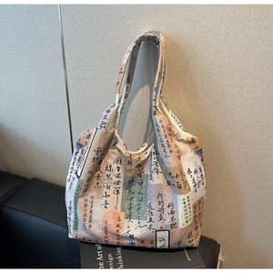 Detail of canvas tote bag with artistic calligraphy pattern on a leather sofa