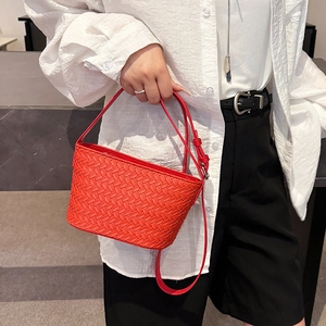 Macro shot of red woven faux leather handbag with wide Intrecciato pattern detail