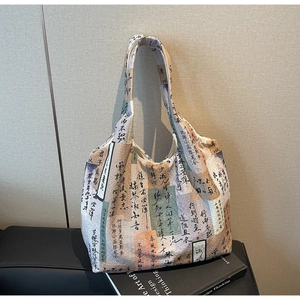 Detail of artistic canvas tote bag featuring Chinese calligraphy on black leather bench