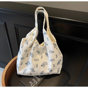 Detail of white tote bag featuring blue koi fish print on waffle textured fabric