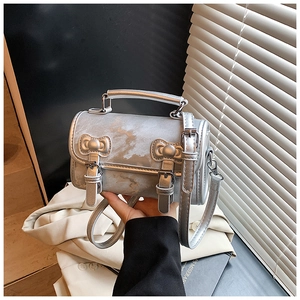 Detail of silver marble pattern mini box bag with decorative bow and top handle