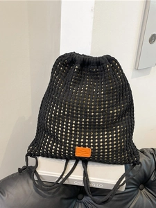 Black hand-knitted drawstring bucket bag with hollow floral mesh and orange label