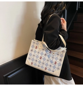 Détail du sac cabas crème avec imprimé ours à losanges bleus et coins renforcés en cuir
