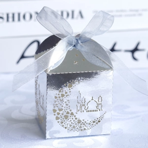 Detail of silver mirror wedding favor box with moon cutout and blue organza ribbon bow