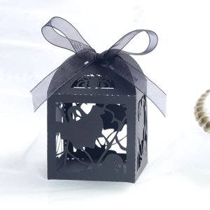 Detail of laser-cut Halloween candy box with spider web and ghost patterns and black ribbon
