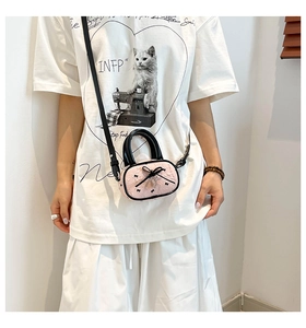 Dettaglio della mini borsa a cuscino rosa balletcore con fiocco nero e ricamo raffinato