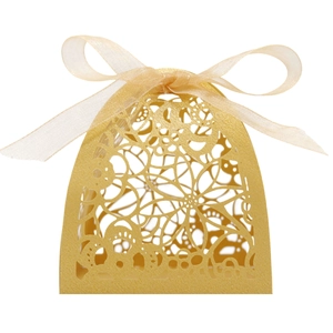 Macro detail of laser-cut floral pattern on golden gift box with a soft satin ribbon