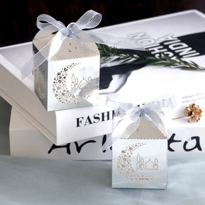 Detail of silver laser-cut Eid Mubarak candy box with moon mosque patterns and ribbon bow