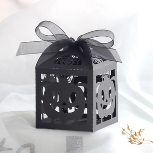 Detail of laser-cut black Halloween candy box with hollow pumpkin and spider patterns