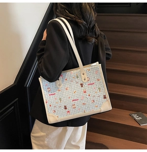 Détail d'un grand sac cabas en tweed bleu clair avec motifs portés à l'épaule