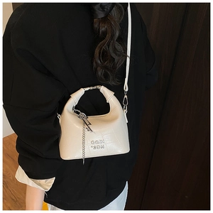 Detail showing the white crocodile-patterned hobo bag with a silver chain accessory