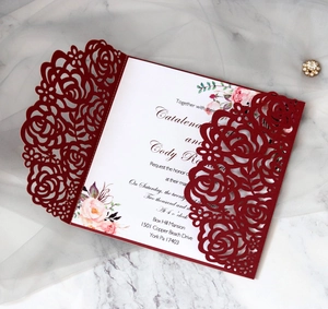 Detail of laser-cut burgundy rose wedding invitation with elegant watercolor floral insert